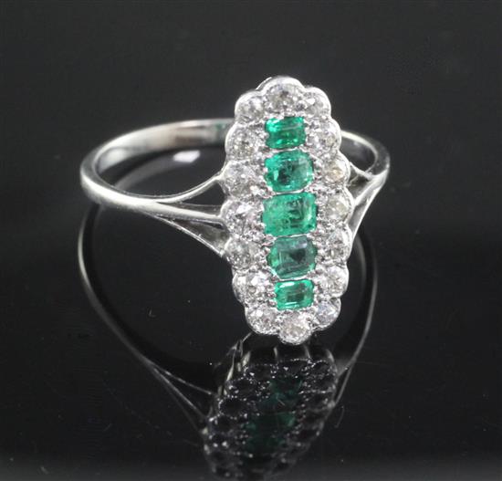 An 18ct white gold and emerald and diamond oval dress ring, size R.
